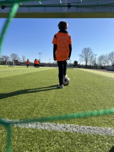 Kind im orangenen Home of Goals Trikot